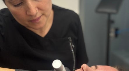 Skilled therapist performing skin treatment at Amorè beauty, Baldock, England, GB. Relaxed client enjoying care.