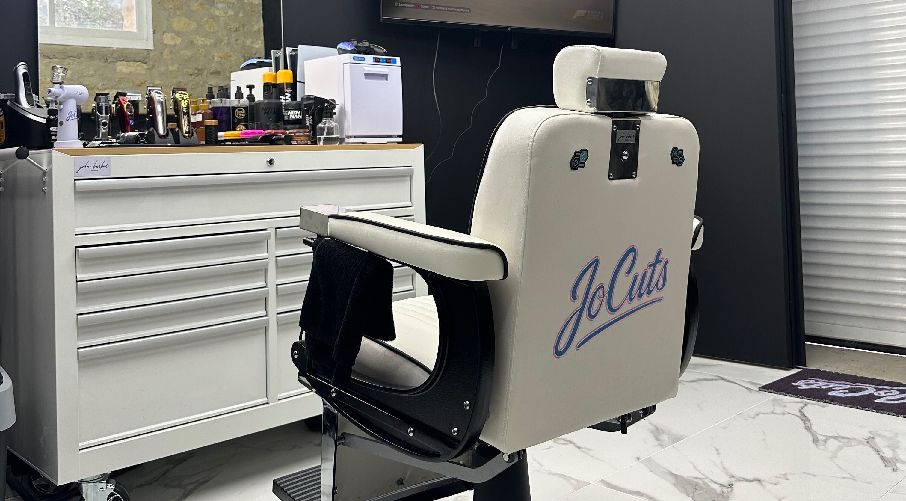 Chaise de coiffure Jocuts à Avenay, Normandie, FR avec outils de coiffure en arrière-plan.