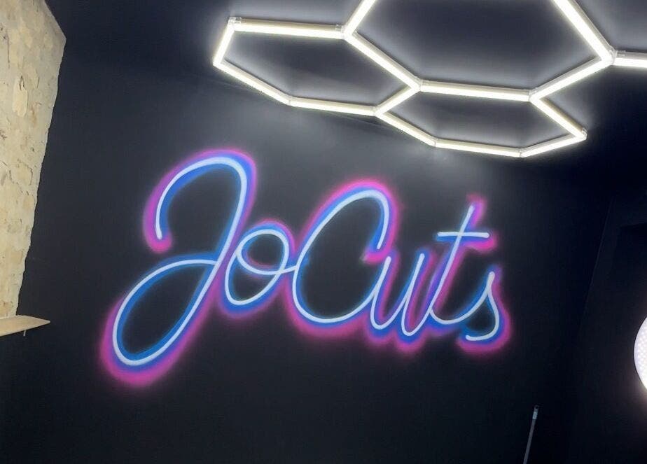 Logo lumineux de Jocuts sur un mur intérieur à Avenay, Normandie, FR.