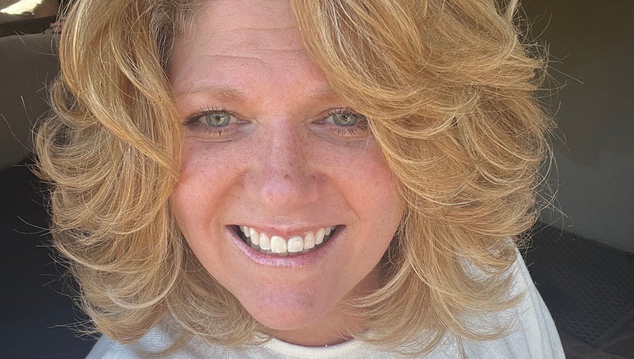 Smiling woman with blonde curls at Hair by Alisha - Pine Grove, California, US.