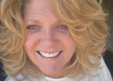 Smiling woman with blonde curls at Hair by Alisha - Pine Grove, California, US.