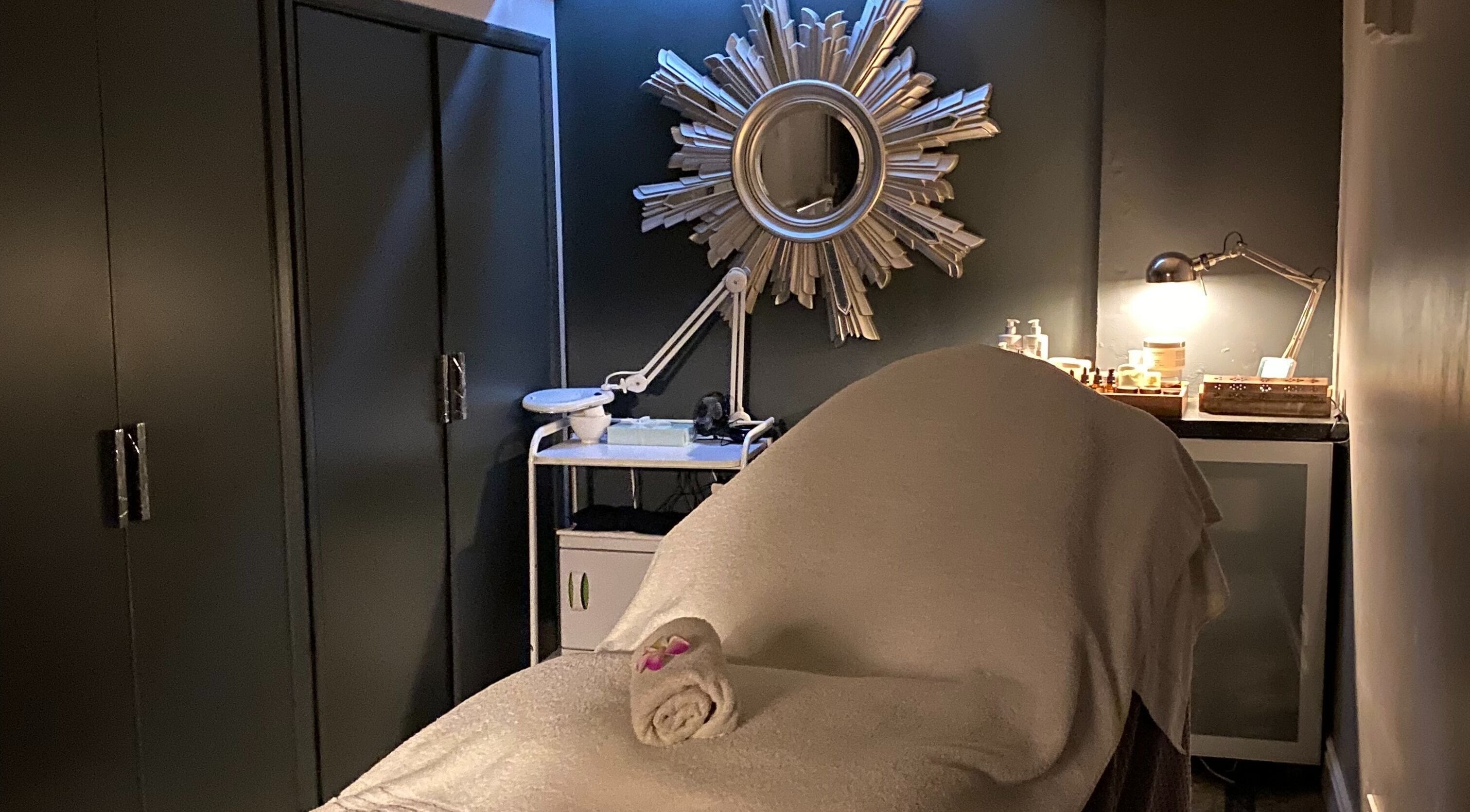 Relaxing treatment room at Crystal Palace, London, England, GB with spa bed and decorative mirror.