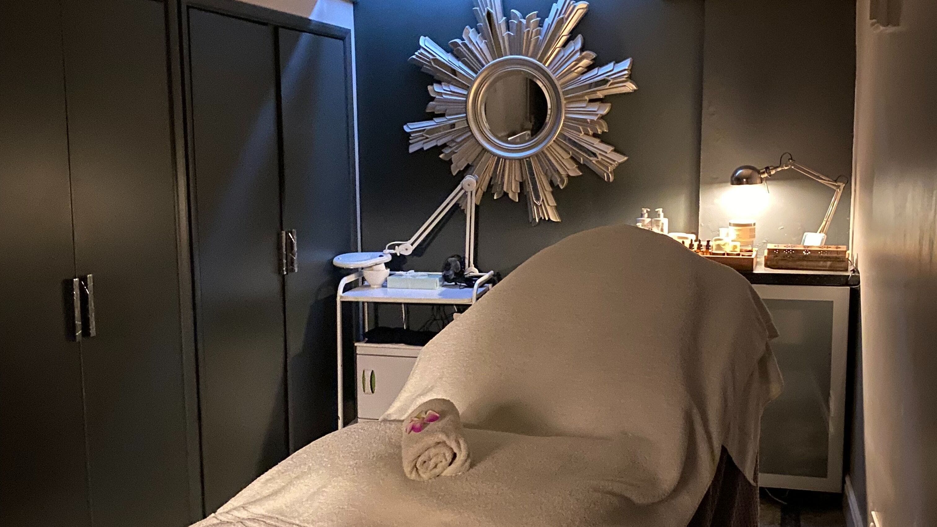 Relaxing treatment room at Crystal Palace, London, England, GB with spa bed and decorative mirror.