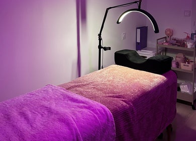 Salle de massage apaisante chez O’Glam à Servas, Auvergne-rhône-alpes, FR, baignées de lumière violette.