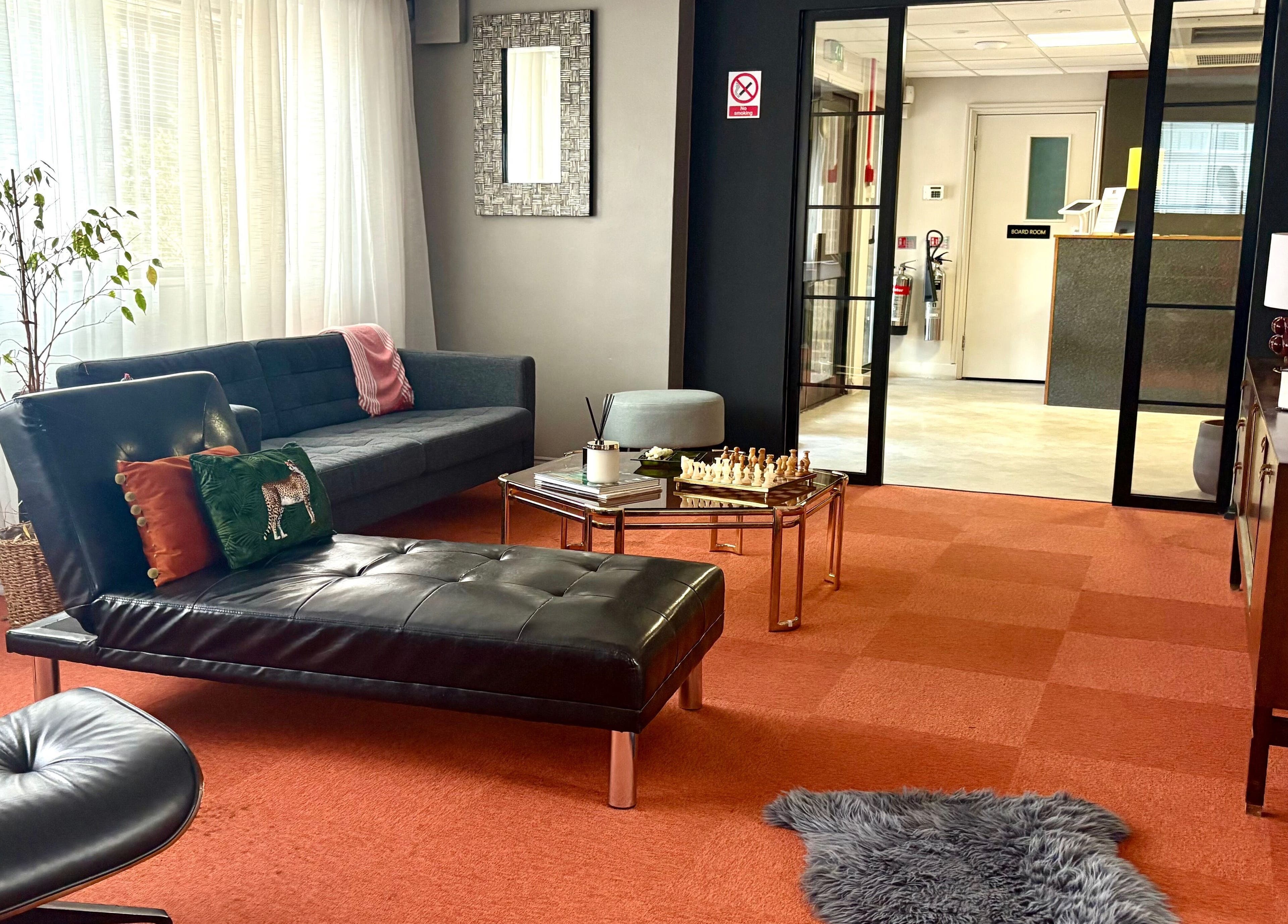 Cozy lounge at Daniva Wellness in Cuffley, GB with leather seating, chess set, and soft lighting.