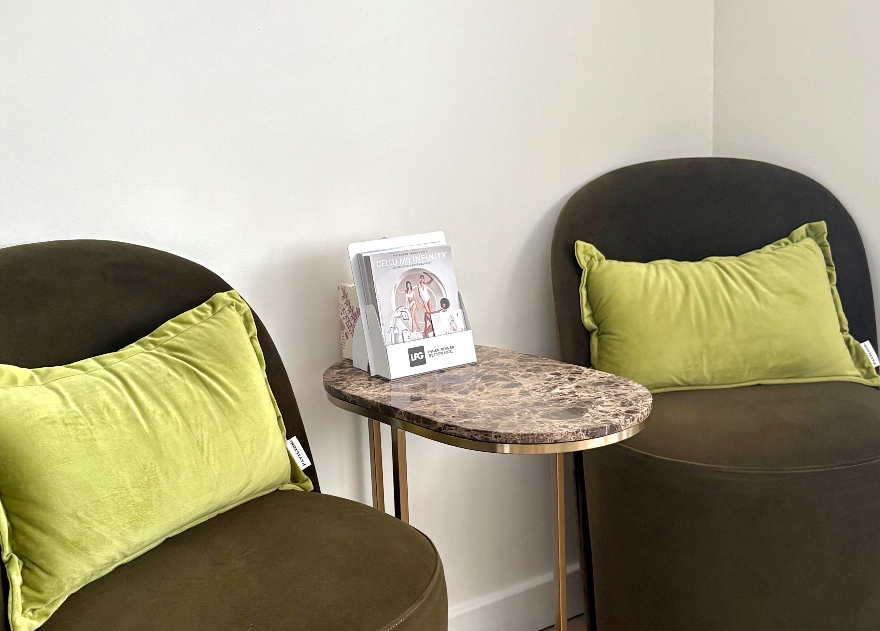 Relaxing seating area with plush chairs at Daniva Wellness in Cuffley, GB featuring a chic marble table.