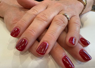 Close-up of nails with red polish at Aurora Beauty Studio, Newton Poppleford, England, GB.