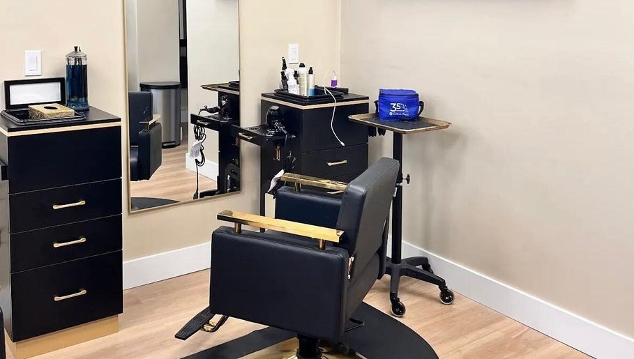 Modern salon interior at Aslanian Styles in South Miami, Florida, US featuring sleek black and gold furnishings.