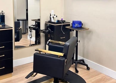 Modern salon interior at Aslanian Styles in South Miami, Florida, US featuring sleek black and gold furnishings.