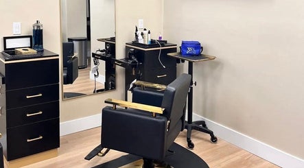 Modern salon interior at Aslanian Styles in South Miami, Florida, US featuring sleek black and gold furnishings.