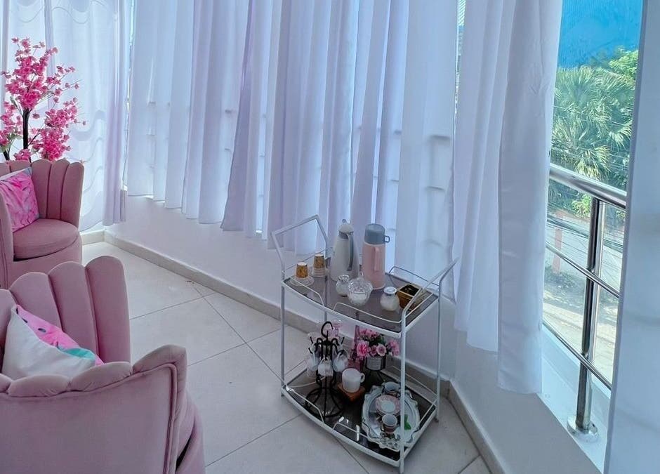 Acogedor rincón de Yaya Beauty Studio en San Pedro De Macorís con sillas rosas y decoración elegante.