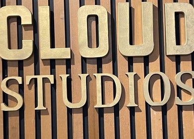 Gold embossed Cloud Studios sign on a wooden background at Charmed, Stafford, England, GB.