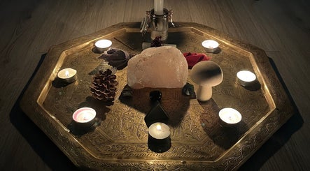 Tranquil candle and crystal arrangement at EyeAmHealing, Wolverhampton, England, GB on intricate brass tray.