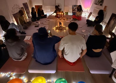 Group meditation at EyeAmHealing in Wolverhampton, England, GB, with candles and calming decor.