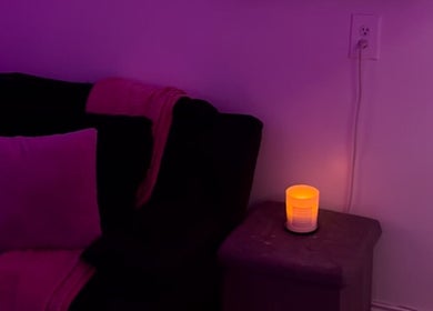 Cozy candlelit corner in The Nail Bar by Cortni, La Marque, Texas, US, featuring purple pillows and ambient lighting.