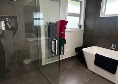 Luxurious bathroom at KJCleans, Manawatu, Manawatū-whanganui Region, NZ featuring modern tub and glass shower.