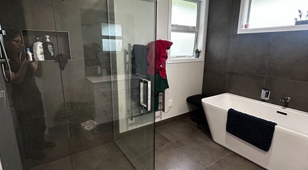 Luxurious bathroom at KJCleans, Manawatu, Manawatū-whanganui Region, NZ featuring modern tub and glass shower.