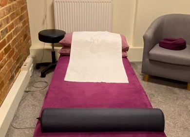 Relaxing therapy room at Matter of Clarity, Finchampstead, England, GB with purple massage table and chair.