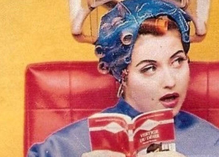 Mujer con rulos en salón BeautyNails&Lashes en Alcalá De Henares, Comunidad De Madrid, ES, leyendo un libro.