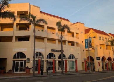 Massage One Wellness (Venice) in Venice, CA, US. Elegant facade with palm trees in warm sunset light.