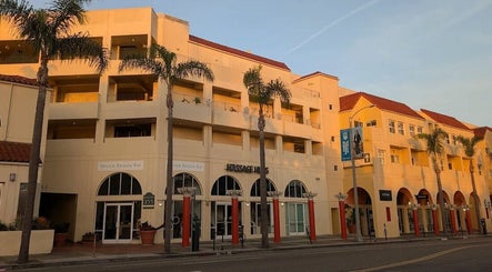 Massage One Wellness (Venice) in Venice, CA, US. Elegant facade with palm trees in warm sunset light.