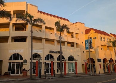 Exterior view of Massage One Wellness (Venice) in Venice, CA, US with palm trees and sunset glow.