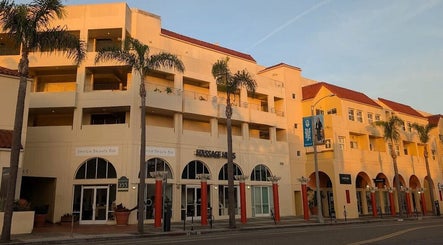 Exterior view of Massage One Wellness (Venice) in Venice, CA, US with palm trees and sunset glow.