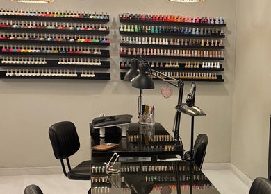 Mesa de manicura en Oasis Nails Spa by Yarimar, San Juan con una variedad de esmaltes en exhibición.