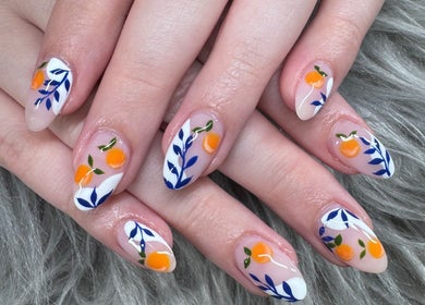 Artistic nail design at Leah nail studio, Kirkland, Washington, US, featuring orange fruit motifs.