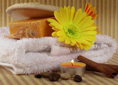 Main Avenue Spa - Home Service offers a serene setup with candles, towels, and flowers in Abu Dhabi, Abu Dhabi, AE.