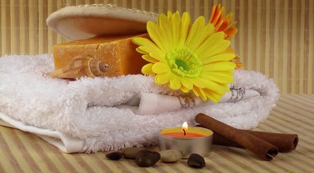 Main Avenue Spa - Home Service offers a serene setup with candles, towels, and flowers in Abu Dhabi, Abu Dhabi, AE.