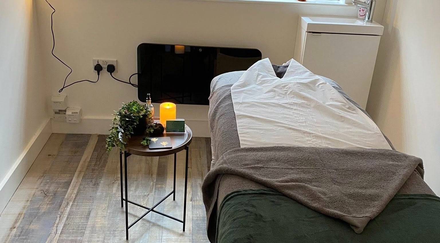 Cozy massage room at Pure Serenity By Hope in Norwich, England, GB with candlelit ambiance.