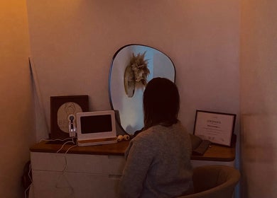 Visitor seated at Beau’s Head Spa in Towcester, England, observing elegant decor in mirror reflection.