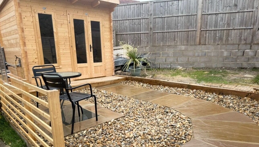 Outdoor seating and wooden cabin at KB Hair, Winchester, England, GB, offering a tranquil atmosphere.