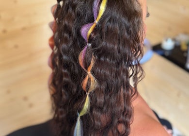 Vibrant rainbow hair twist at KB Hair, Winchester, England, GB. Stunning salon style with colorful highlights.