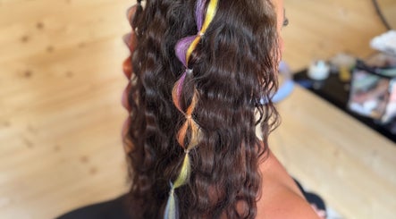 Vibrant rainbow hair twist at KB Hair, Winchester, England, GB. Stunning salon style with colorful highlights.