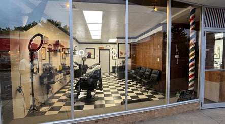 Interior of Good Fellas Barbershop in Medicine Hat, Alberta, CA, showcasing classic barber chairs and checkered flooring.