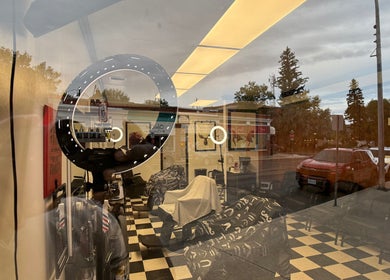 Interior view of Good Fellas Barbershop through window reflection in Medicine Hat, Alberta, CA.
