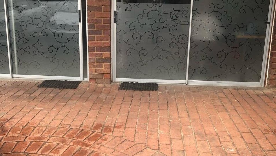 Elegant entrance at Vuyo's Sanctuary, Sandton, Gauteng, ZA with intricate glass designs and brick pathway.