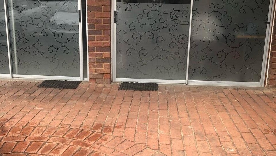 Elegant entrance at Vuyo's Sanctuary, Sandton, Gauteng, ZA with intricate glass designs and brick pathway.