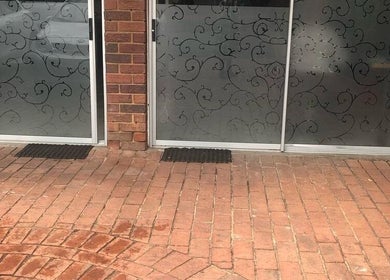 Elegant entrance at Vuyo's Sanctuary, Sandton, Gauteng, ZA with intricate glass designs and brick pathway.