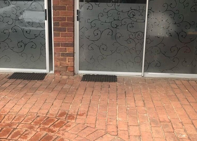 Elegant entrance at Vuyo's Sanctuary, Sandton, Gauteng, ZA with intricate glass designs and brick pathway.