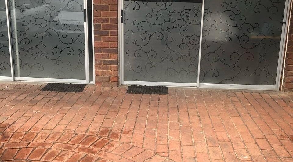 Elegant entrance at Vuyo's Sanctuary, Sandton, Gauteng, ZA with intricate glass designs and brick pathway.