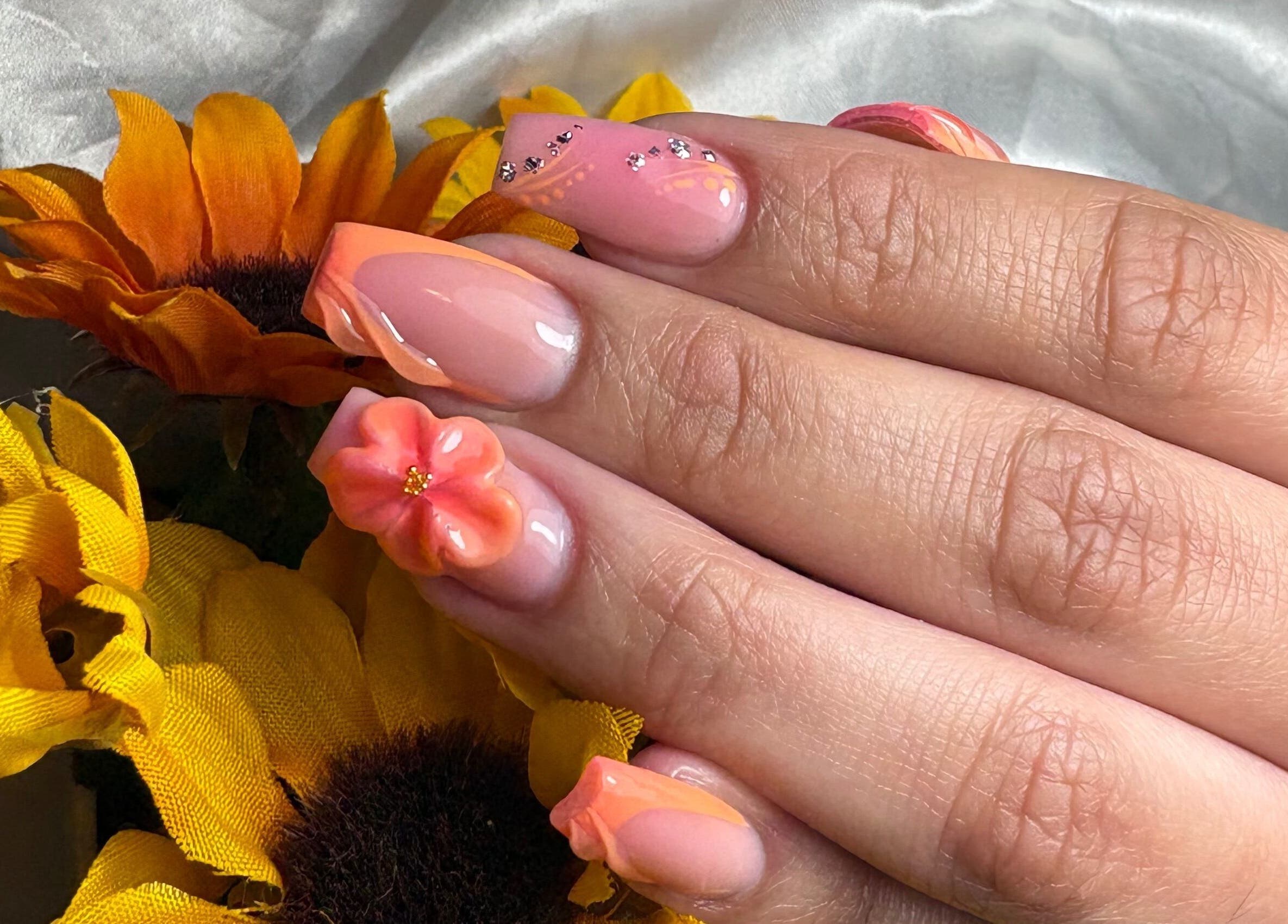 Diseño de uñas florales con tonos naranjas en By Mariet Pérez nails, Orlando, Florida, US.