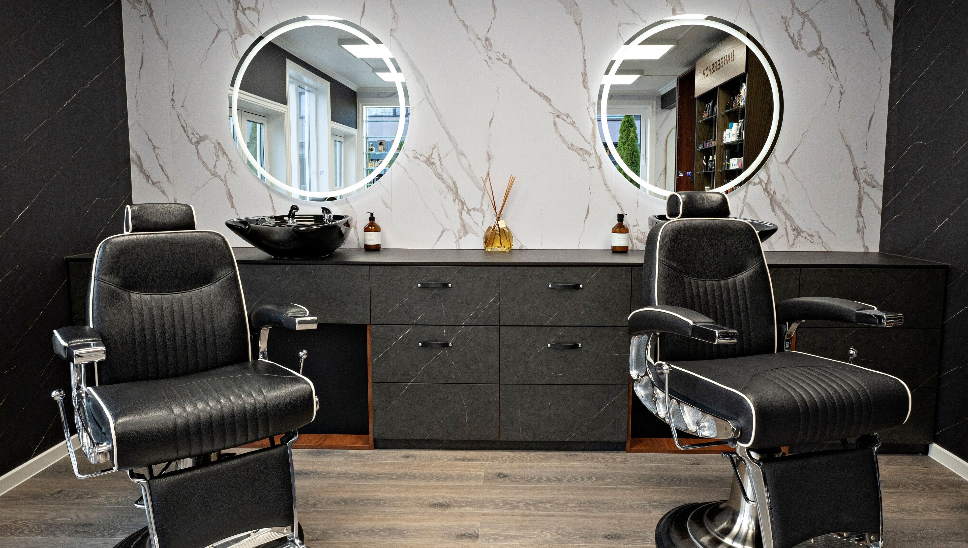 Luksuriøse frisørstoler i Alpha Grooming, Oslo, Oslo, NO, med stilige speil og marmorveggdekor.