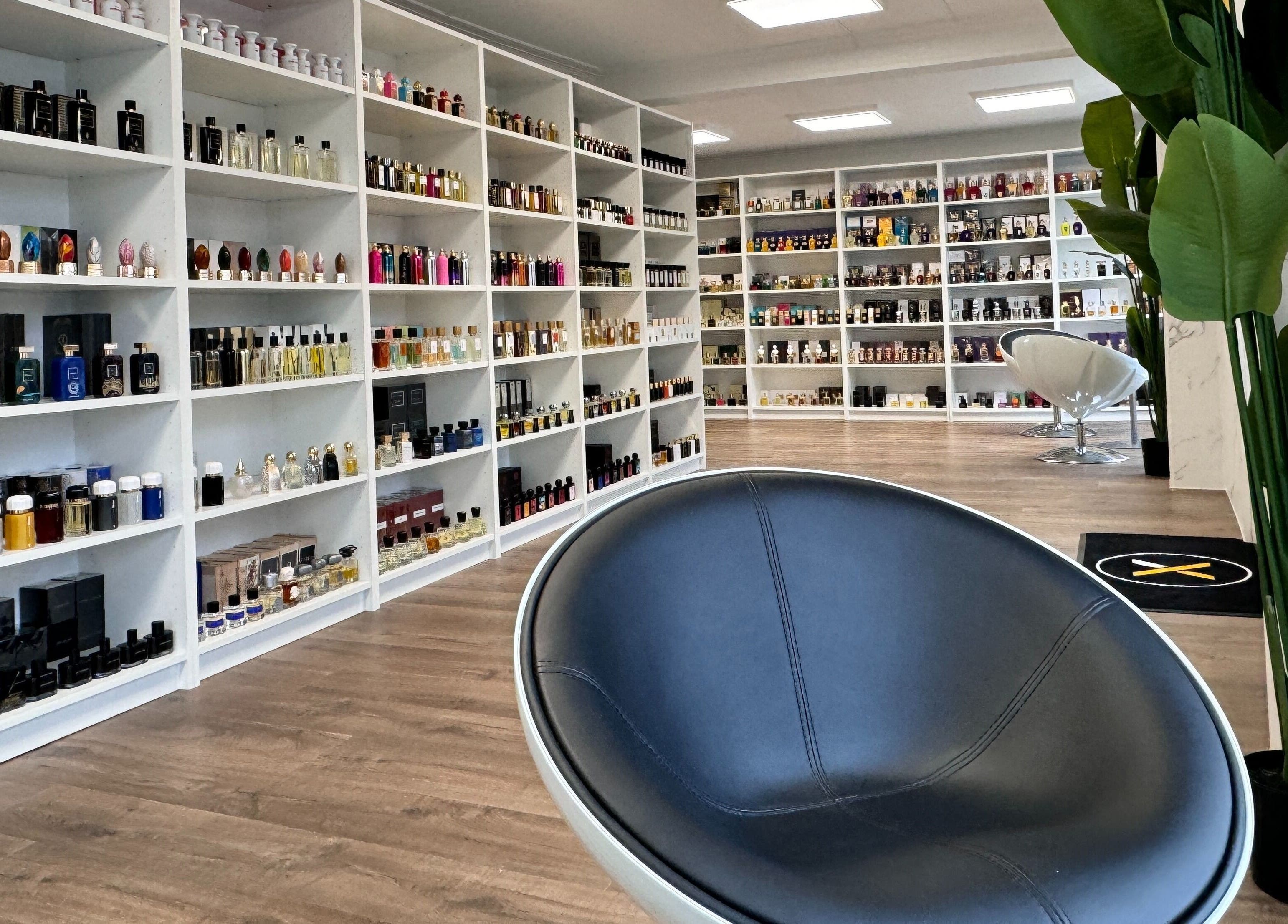 Moderne parfymebutikk hos Alpha Grooming, Oslo, Oslo, NO, med forskjellige flasker på hvite hyller.