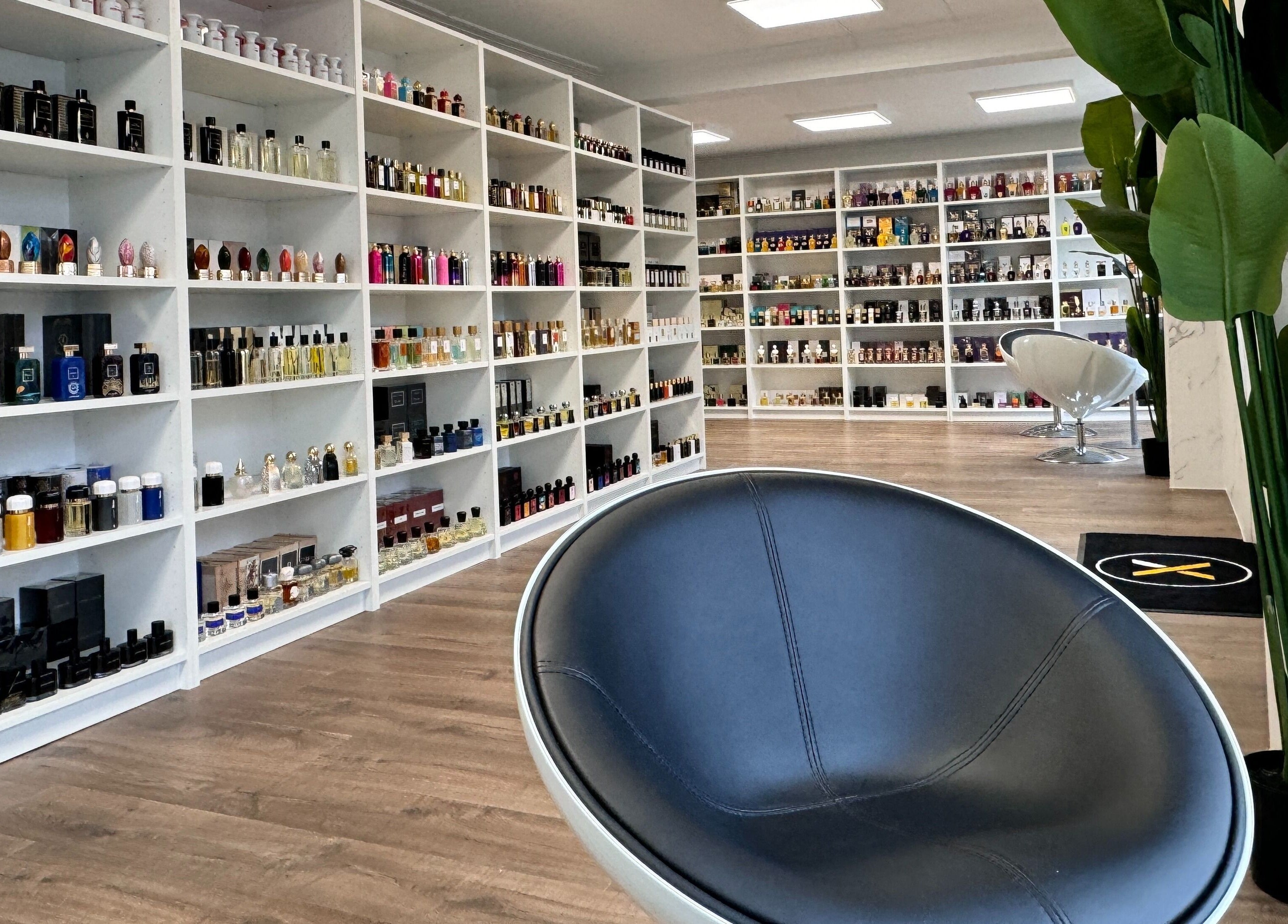 Moderne parfymebutikk hos Alpha Grooming, Oslo, Oslo, NO, med forskjellige flasker på hvite hyller.