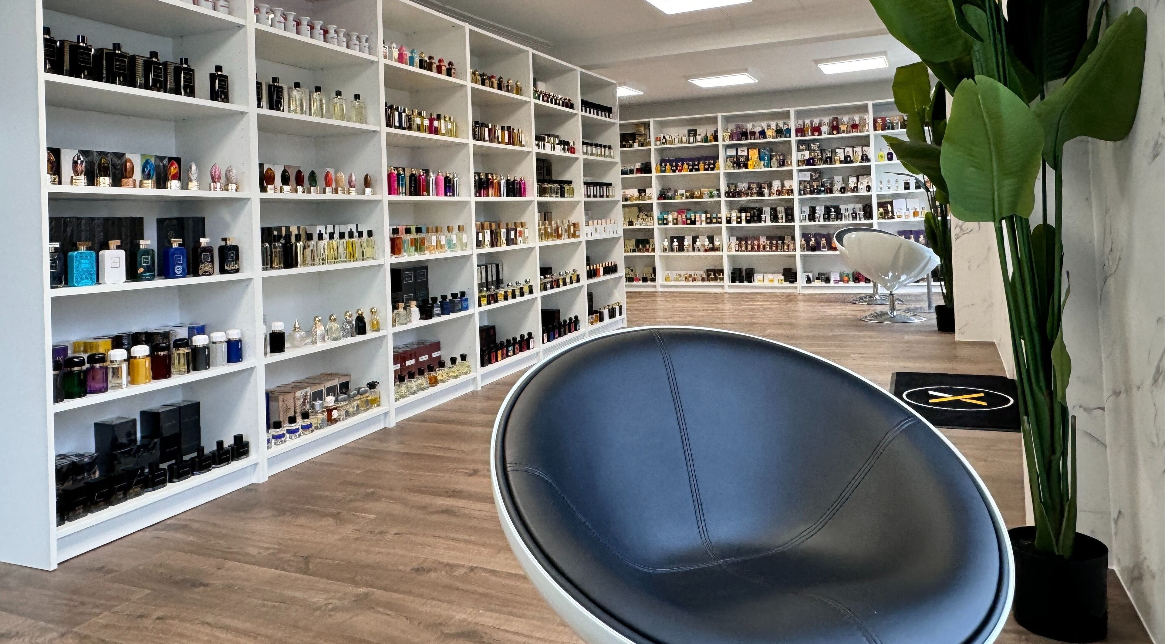 Moderne parfymebutikk hos Alpha Grooming, Oslo, Oslo, NO, med forskjellige flasker på hvite hyller.