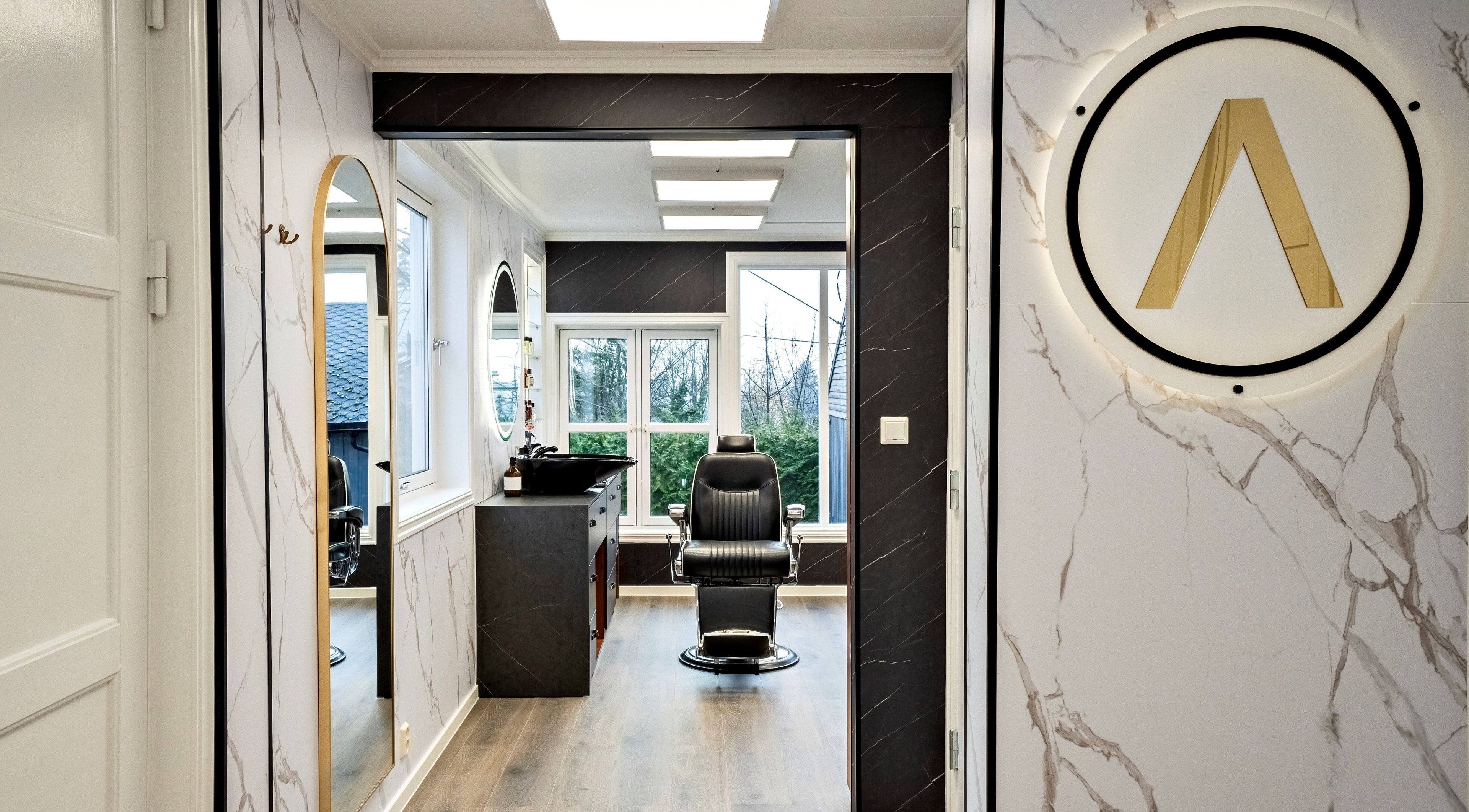 Romslig frisørsalong hos Alpha Grooming, Oslo, Oslo, NO, med moderne interiør og luksuriøs stol.