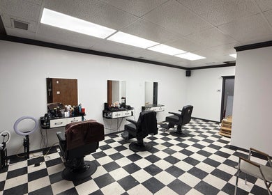 Interior of Carlos the barber, Medicine Hat, Alberta, CA, showing chic black and white décor with barber chairs.